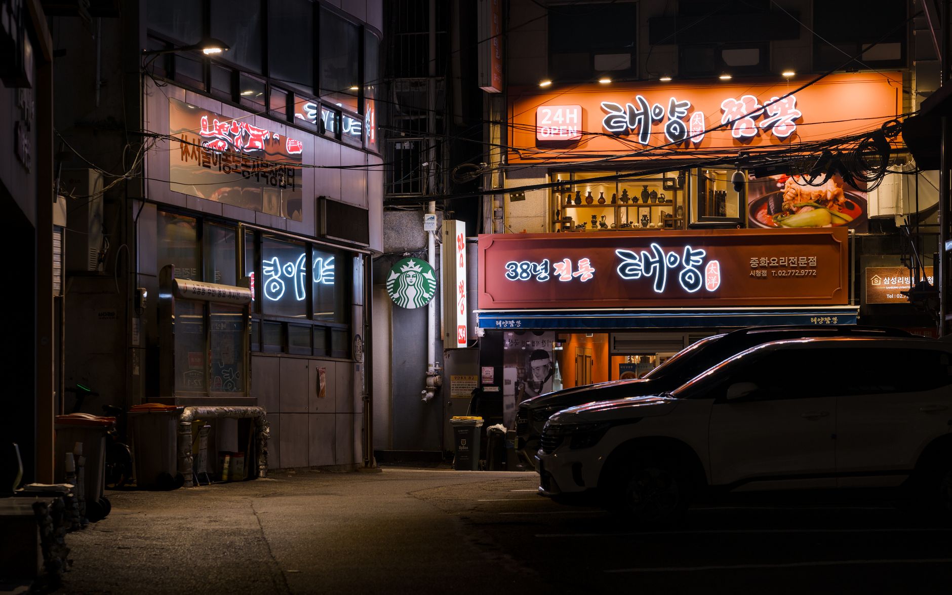 Neon-lit alleyway in Seoul with vibrant signs and urban charm, showcasing a lively night scene.